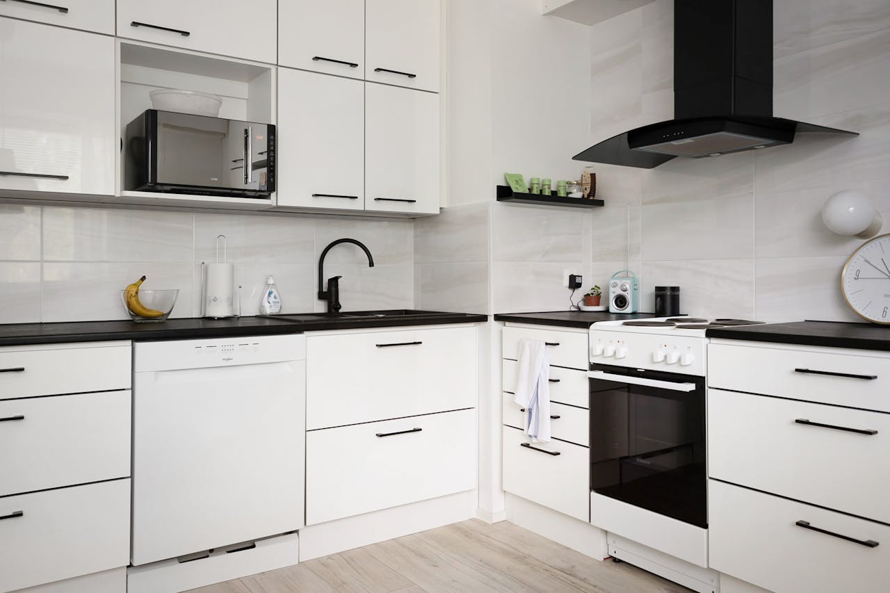 Contemporary white kitchen featuring sleek cabinets and modern appliances.